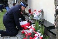 Komendant KP PSP w Kłobucku składa wiązankę kwiatów pod pomnikiem