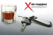 Fotografia przedstawia szklankę z napojem, kluczyki do auta oraz napis &quot;Nie reagujesz - akceptujesz&quot;.