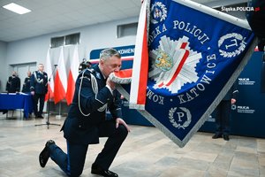 Komendant Wojewódzki Policji w Katowicach całuje sztandar.