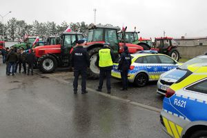 Zdjęcie przedstawia umundurowanych policjantów, oznakowane radiowozy, rolników oraz ciągniki rolnicze.