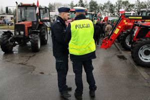 Zdjęcie przedstawia umundurowanych policjantów, rolników oraz ciągniki rolnicze.
